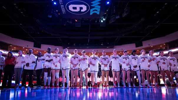 Team standing arm in arm before playing Portland in the WCC Tournament