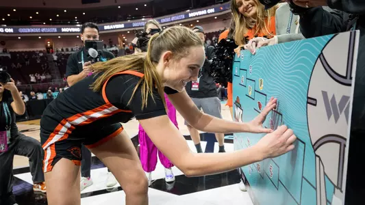Ally Schimel puts the sticker on the bracket after being LMU
