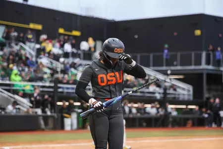 Mya Harrison grabbing her helmet as she walks back to the dugout.