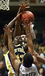 West Virginia's Tim Lyles, center, is blocked by Pittsburgh's Isaac Hawkins, top, as Ricardo Greer defends in the first half in Pittsburgh on Wednesday.