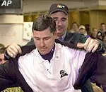 Mitch Morral of the Tangerine Bowl helps Pittsburgh coach Walt Harris with the bowl game jacket after inviting Pittsburgh to the game in Orlando, Fla., after Pittsburgh beat UAB 24-6 finish the season 6-5.