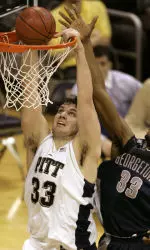 Aaron Gray dunks the ball past Georgetown's Patrick Ewing Jr. in the second half Saturday night. (AP Photo/Keith Srakocic)