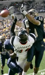 Mike Phillips, right, and Kennard Cox, left, break up a pass in the end zone intended for Cincinnati wide receiver Dominick Goodman in the first quarter. (AP Photo/Keith Srakocic)