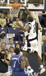 Keith Benjamin, right, dunks the ball over Buffalo's Andy Robinson in the second half.