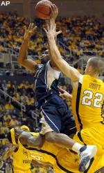 West Virginia players defend as Pittsburgh forward Sam Young drives to the basket during the first half. (AP Photo/Don Wright)
