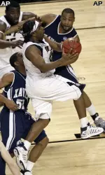 Levance Fields, center, drives for a shot between Xavier's Derrick Brown (52) and Jason Love, right rear, in the first half.