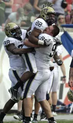 Antwuan Reed (22) celebrates with teammates Chas Alecxih (98) and Greg Williams (38) after intercepting a pass by South Florida quarterback B.J. Daniels as time expired