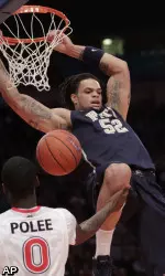 Pittsburgh's Gary McGhee dunks as St John's  Dwayne Polee looks on.