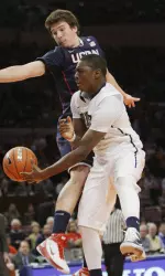 Ashton Gibbs is blocked by Connecticut's Tyler Olander as he goes to the basket during the second half. (AP Photo/Mary Altaffer)