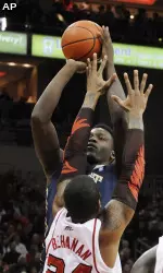 Pittsburgh's Talib Zanna, rear, gets a shot off over Louisville's Chane Behanan.