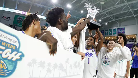 Xavier Johnson holding the Fort Myers Tip-Off Championship trophy.