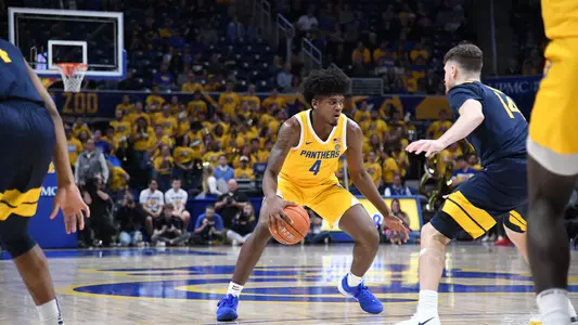 Gerald Drumgoole, Jr. dribbling against a West Virginia defender.