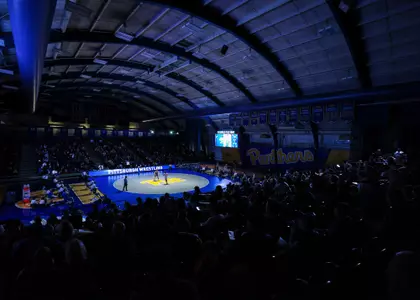 A wide shot of the interior of the Fitzgerald Field House with the lights down for a wrestling match.