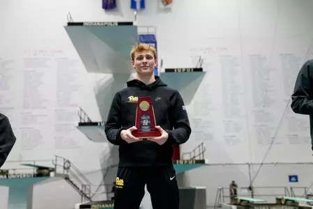 Cameron Cash on podium holding NCAA trophy