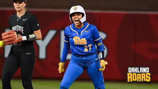 A PItt softball player yells in celebration from second base