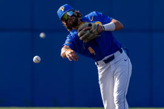 A pitt baseball player makes a throw durring warm ups