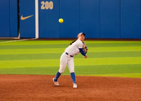 A pitt softball player makes a throw across the infield
