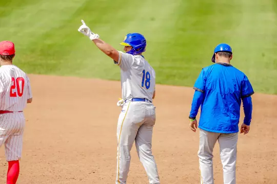 A Pitt baseball players gestures to the dugout after a hit