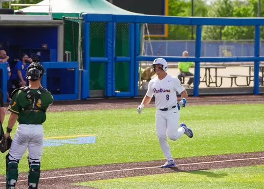 A pitt player returns to home plate after a home run
