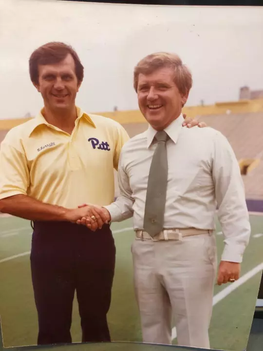 Bill Hillgrove and former Pitt head coach Jackie Sherrill shake hands on the field
