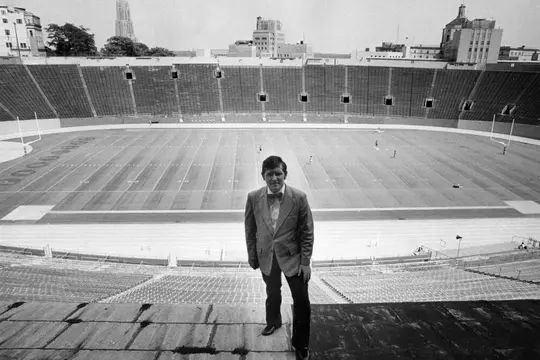 Bill Hillgrove stands in an empty PItt Stadium wearing a Bowtie