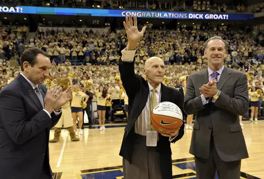 Dick Groat holds a commemorative game basketball while waving to the crowd