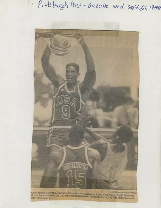 Charles Smith of Pitt dunks the ball over Brazil's Gerson Victalino while Navy's David Robinson, Smith's teammate on the U.S. men's basketball team, watches during the first half of Wednesday night's game.