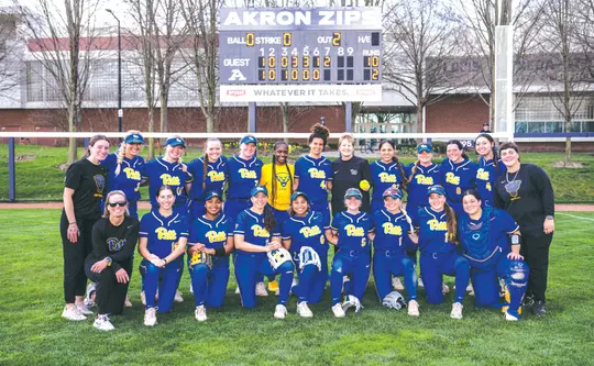 Softball Head Coach Jenny Allard poses with the team after defeating Akron, 10-2, for her 700th career win.