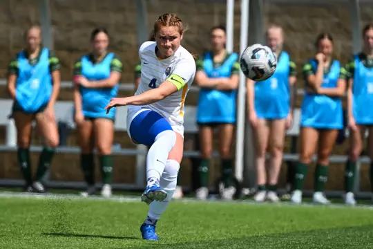 A Pitt women's soccer player kicks the ball