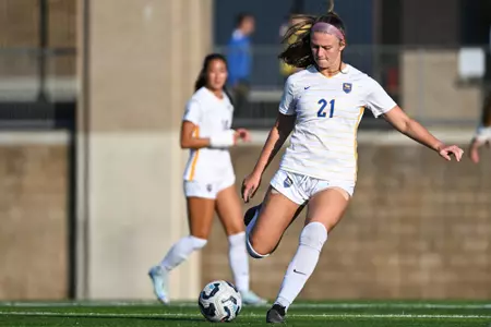 Katie Zailski in #21 uniform seen in stride before kicking a soccer ball