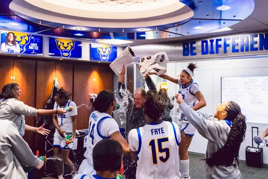 The Pitt women's basketball team celebrates with coach verdi