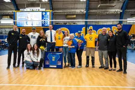 Rachel Fairbanks standing with her coaches and family on senior night