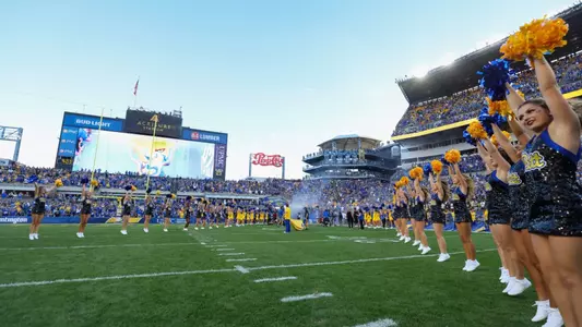A wide shot of the field of acrisure stadium lined with cheerleaders awaiting the team's arrival
