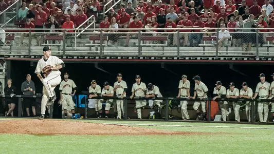 Chad Powers pitches as his team looks on.