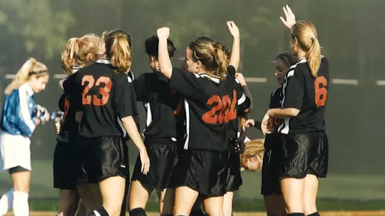 several members of the 2000 team huddle