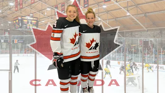 posed photo of claire thompson and sarah fillier with hockey canada and baker rink backgrounds