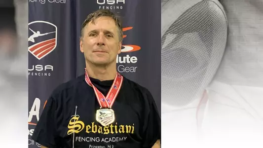 Photo of Paul Epply-Schmidt with medal on fencing background