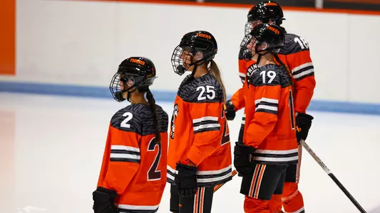 women's hockey players stand ahead of national anthem
