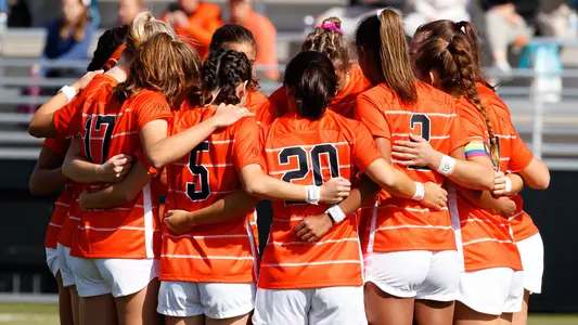 women's soccer huddle photo with pride armband