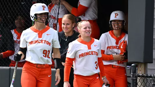 softball players smile in the dugout