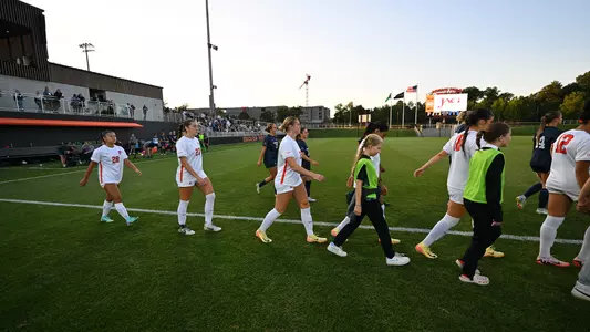 women's soccer team members walk onto the field