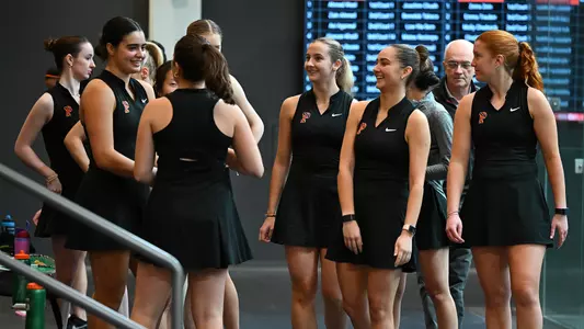 group of women's squash players stand and smile candidly before a match