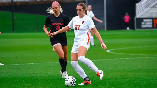 Alexandra Barry dribbles a soccer ball away from a defender