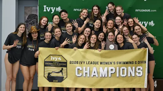 Women's Swimming & Diving with trophy and banner
