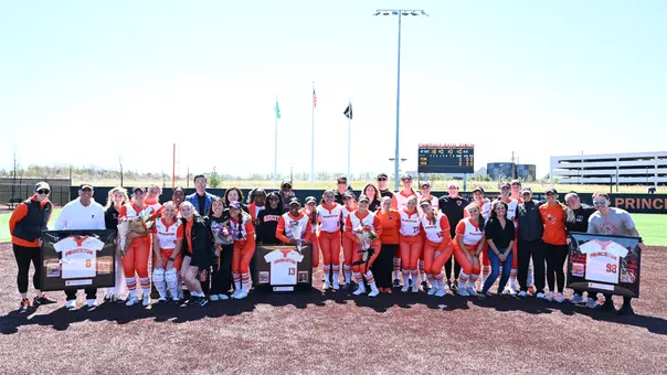 posed photo of softball players and senior families