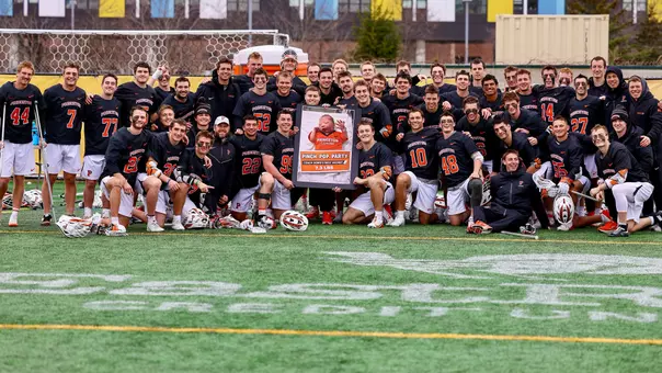 Men's lacrosse team with baby photo
