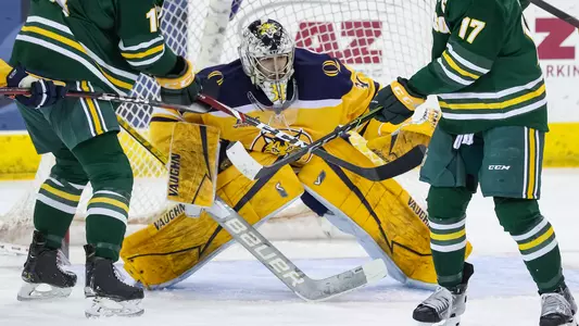 Petruzzelli Looks Between Clarkson Defenders for Puck