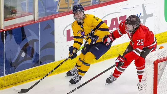Olivia Mobley skates behind the net vs St. Lawrence