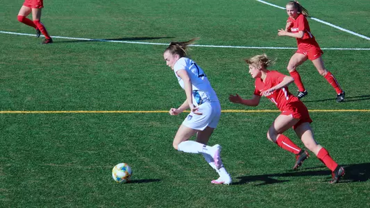 Rebecca Cooke dribbles away from a Marist player