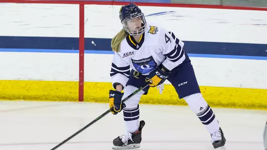 Kendall Cooper sends the puck up the ice vs Colgate